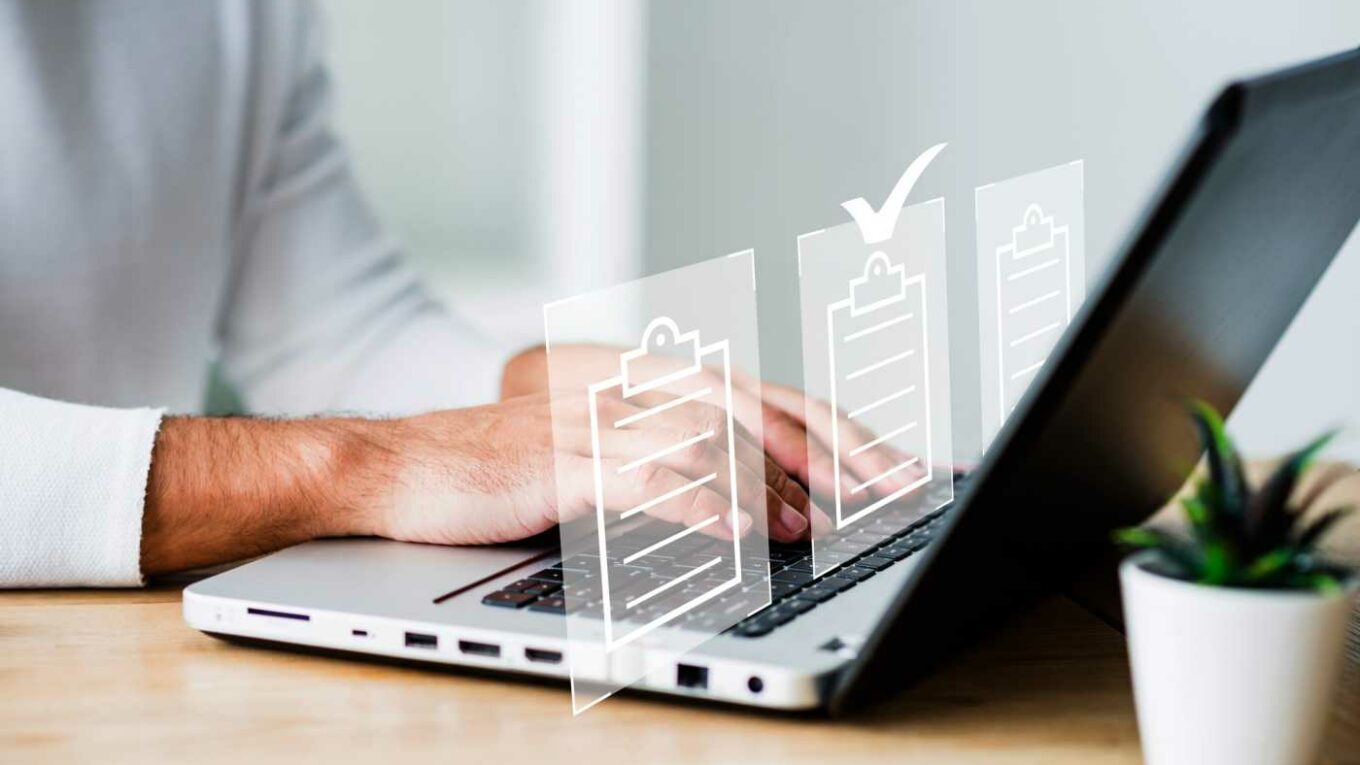 Man focused on a laptop displaying a checklist, indicating project planning.